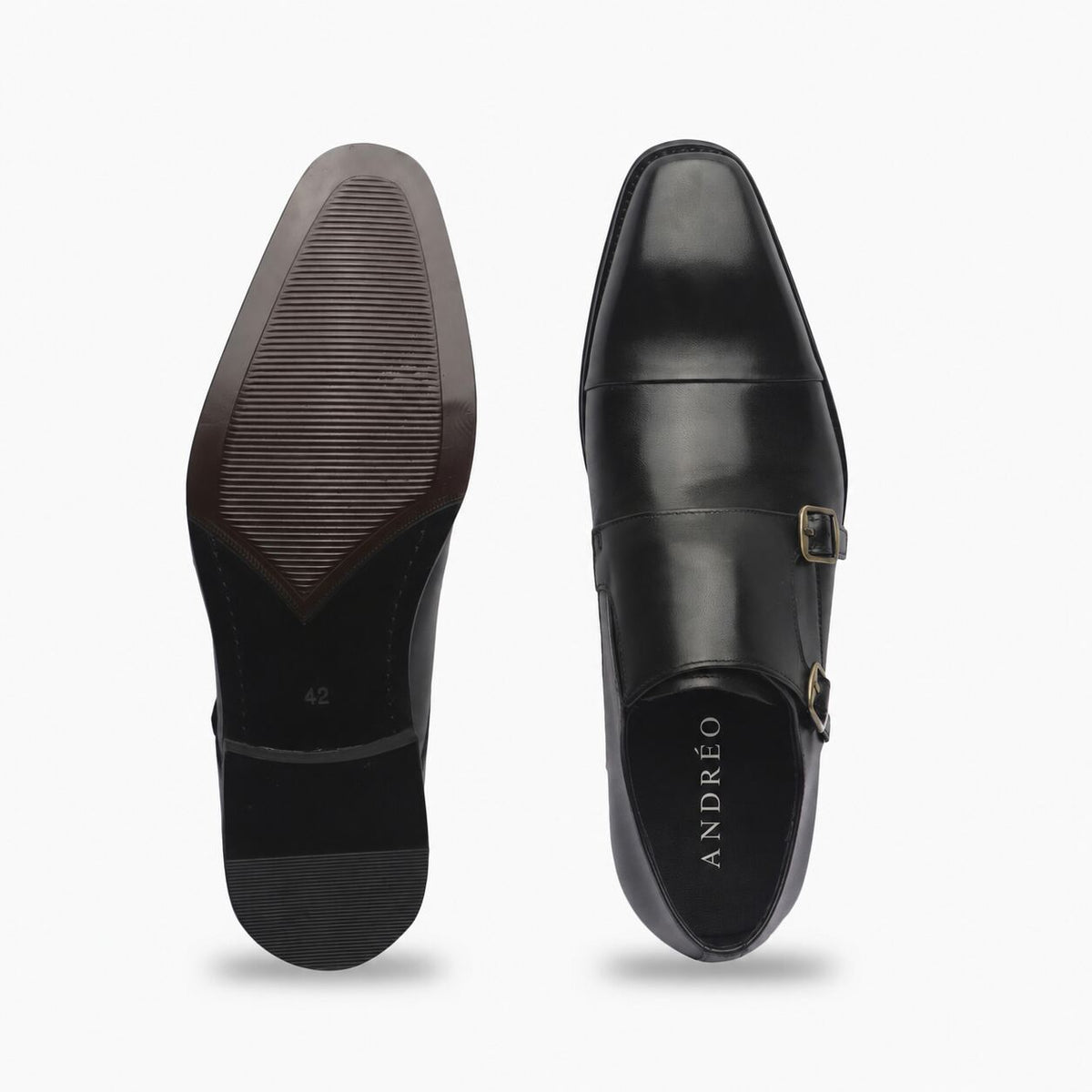 A pair of black leather men's dress shoes shown from the top and sole views against a light gray background. The right shoe displays the black leather upper with a single strap and gold buckle, while the left shoe shows the textured black rubber sole.