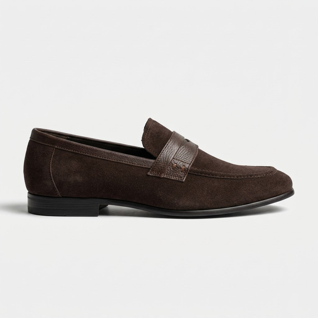 A dark brown suede penny loafer shown in a side profile view against a clean, light gray background.