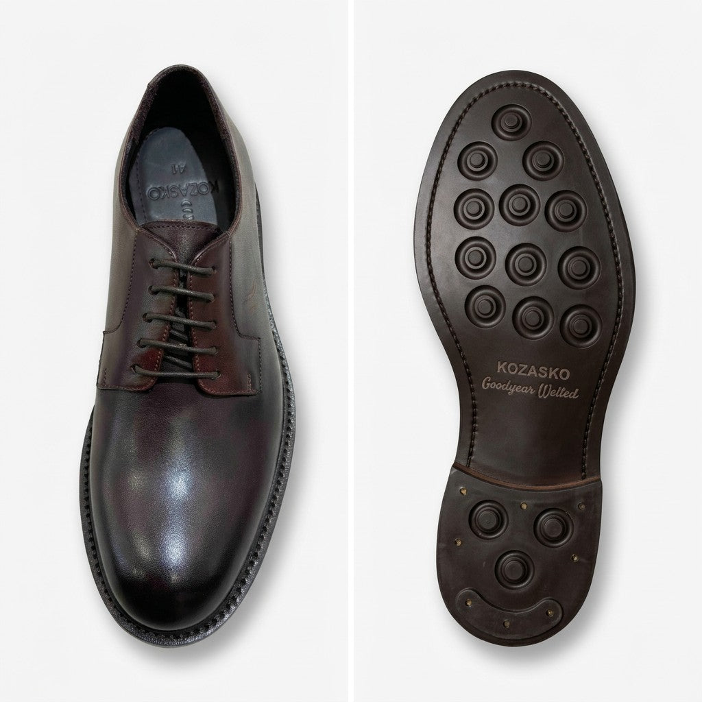 A pair of dark brown leather dress shoes shown from the top, displaying the polished toe and lace-up front, alongside the outsole with circular tread patterns and 'KOZASKO' branding.