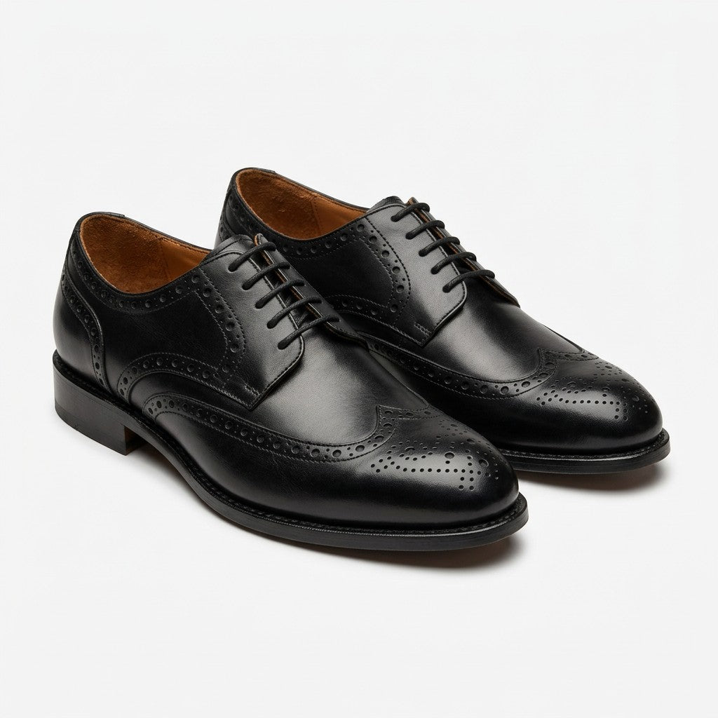 A pair of black leather wingtip oxford shoes with decorative brogue perforations, displayed on a clean white background.