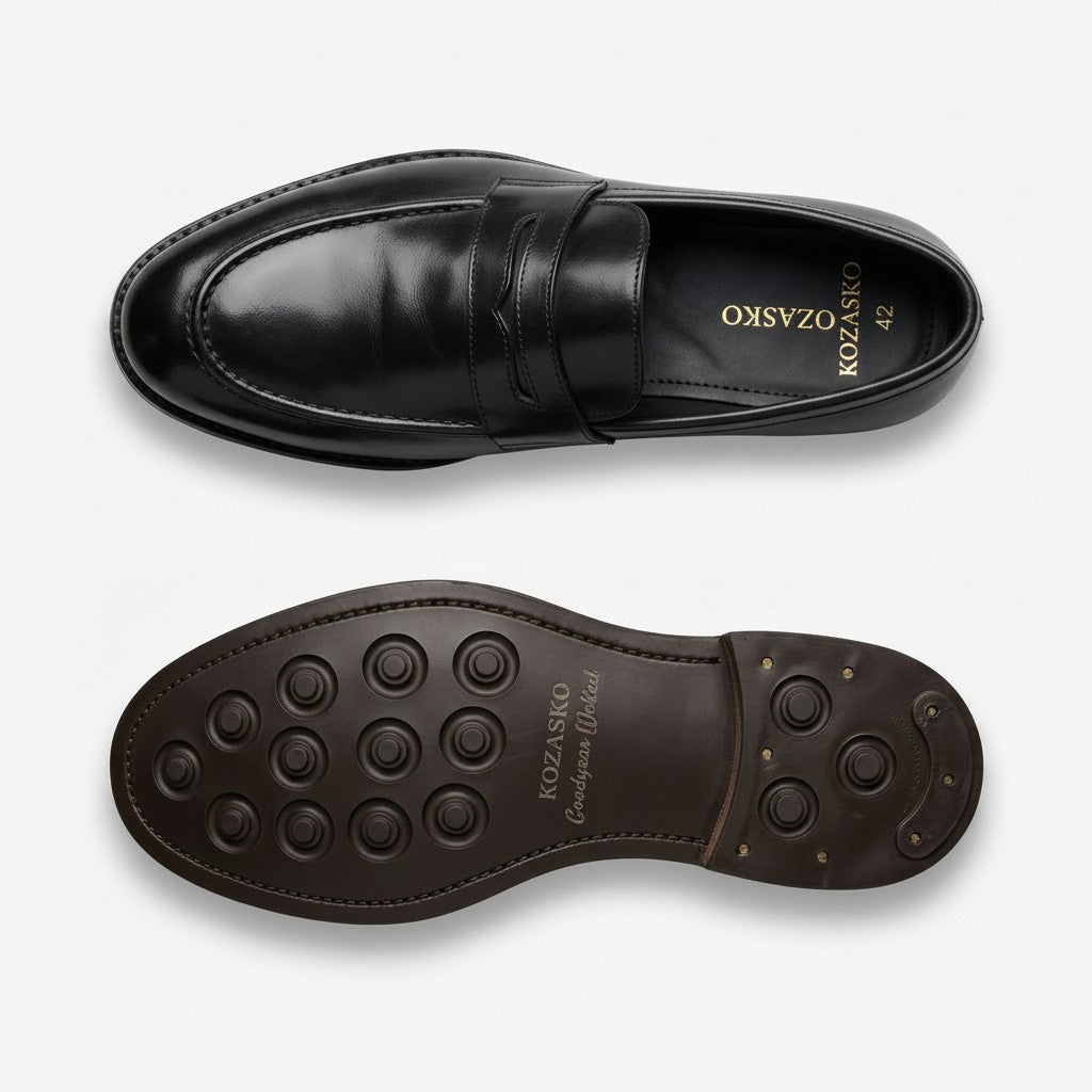 A pair of black leather penny loafers shown from the top and bottom, with the brand name 'Kozasko' visible on the insole and outsole, set against a clean white background.