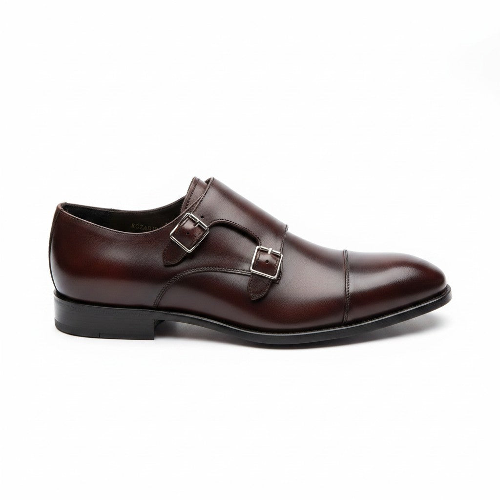 A dark brown leather double strap monk-style dress shoe with a cap toe and polished finish, shown from a side profile on a white background.